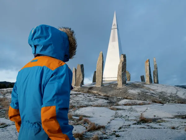 A child looking towards Solspeilet and its standing stones