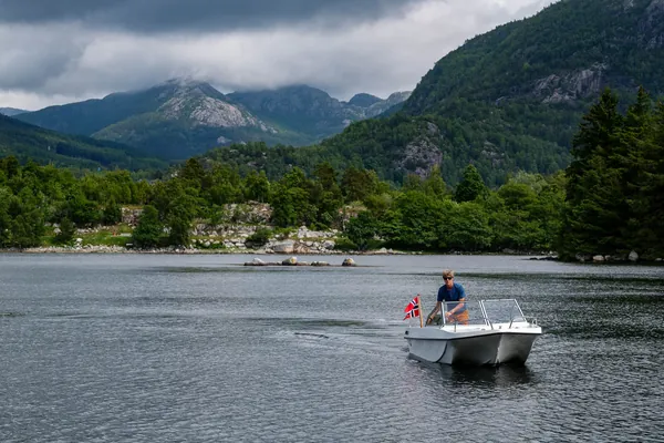 Trifoil 100GT moving across the water beneath mountains
