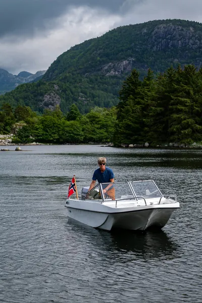 Trifoil 100GT viewed from the front on the water beneath wooded mountains