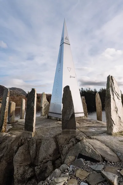 Solspeilet rising behind its standing stones
