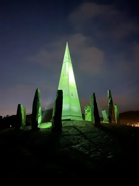 Solspeilet illuminated in green at night